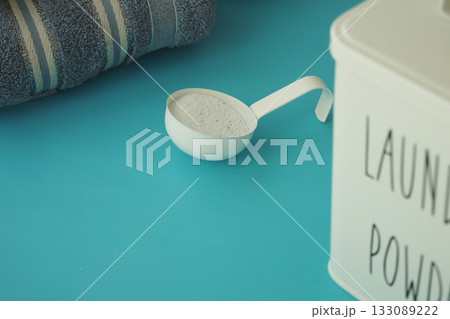 Laundry powder scoop and towel on blue surface 133089222