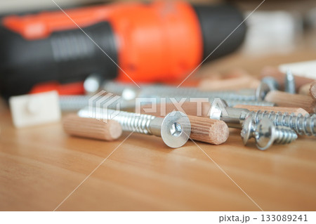 Tools and screws on wooden surface ready for assembly 133089241