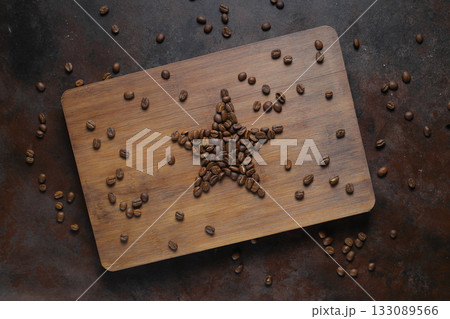 Roasted coffee beans shaping star on dark rustic background. Roasted coffee beans shaping star on dark rustic background. 133089566