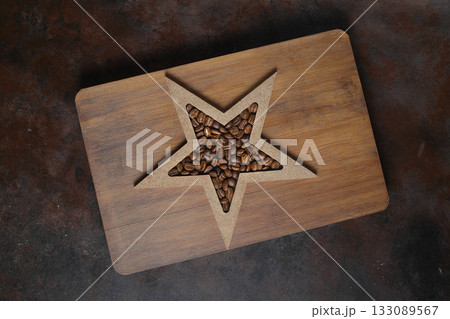 Roasted coffee beans shaping star on dark rustic background. 133089567