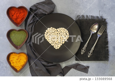 white kidney beans in a heart shaped black plate a on white background. Top view. 133089568