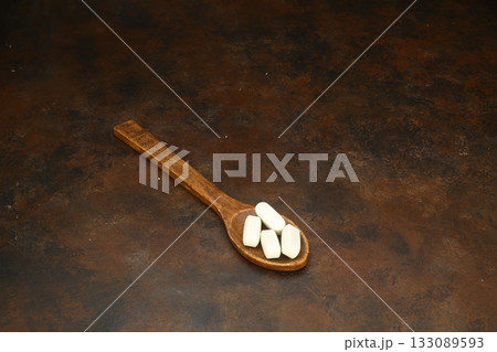 Healthcare concept of ladle with spoon of various medicine tablet, caplets, pills, capsule on rusty background 133089593
