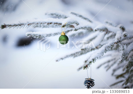 Snow covered fir branches with Christmas decorations on winter outdoor 133089853