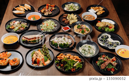 Assorted restaurant dishes on a wooden table, overhead flat lay of a catering menu Assorted restaurant dishes on a wooden table, overhead flat lay of a catering menu 133090032
