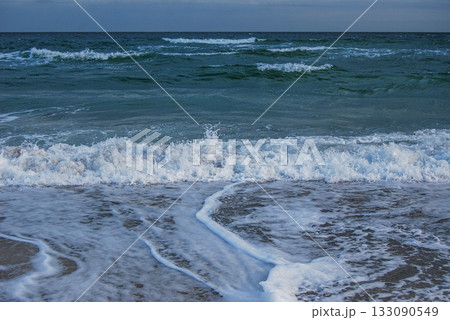 Beautiful seascape of the Black Sea. A seascape of the Black Sea with gentle waves lapping a sandy beach. Beautiful seascape of the Black Sea. A seascape of the Black Sea with gentle waves lapping a sandy beach. 133090549