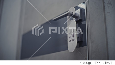 Young Woman Enters Hotel Room and Gently Hangs Do Not Disturb Sign on Door Handle Young Woman Enters Hotel Room and Gently Hangs Do Not Disturb Sign on Door Handle 133091691