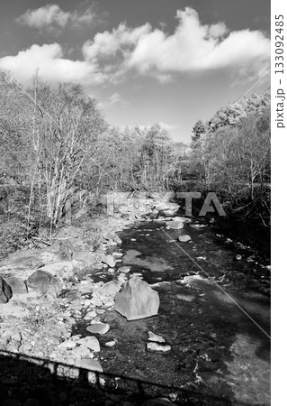 秋の「北湯沢温泉」橋の上から見る「長流川」白黒 133092485