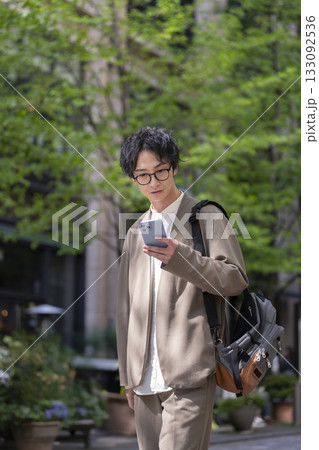街角でスマートフォンの画面を見る0代後半の男性 133092536