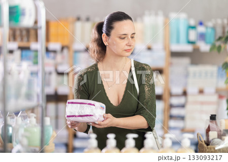 Middle-aged woman choosing feminine pads in chemistry Middle-aged woman choosing feminine pads in chemistry 133093217