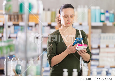 Woman in cardigan scans package of paracetamol Woman in cardigan scans package of paracetamol 133093228