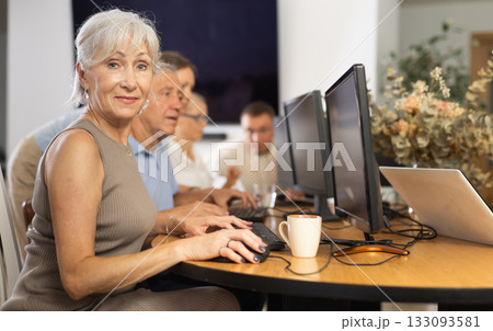 Elderly woman studying at computer course in group 133093581