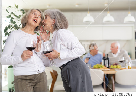 Two elderly women friends talking in kitchen Two elderly women friends talking in kitchen 133093768