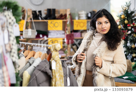 Latina chooses a fur coat in the store Latina chooses a fur coat in the store 133093879