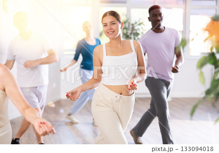 Young teacher and group of positive aged people engaged in dynamic dances Young teacher and group of positive aged people engaged in dynamic dances 133094018