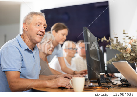 Enthusiastic senior man attending computer class for older adults 133094033