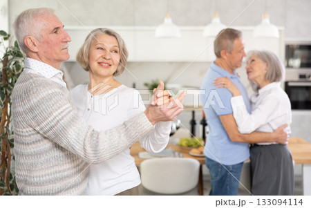Senior men and women doing couple dancing during house party. 133094114
