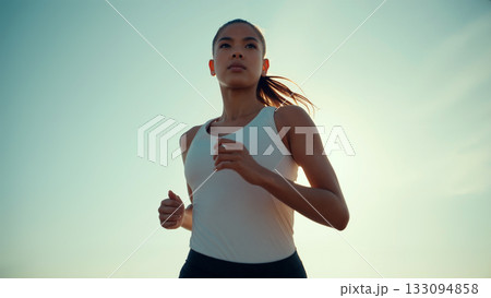 Morning Runner Enjoys a Peaceful Jog Under a Clear Sky at Sunrise 133094858