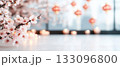 Delicate cherry blossom branches illuminate a serene indoor setting with soft lighting. 133096800