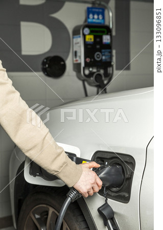 Charging an electric vehicle at a charging station 133096851