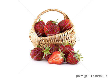 Fresh strawberries spilling from wicker basket on white background 133098003