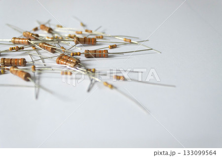 Assorted electronic resistors scattered on white background 133099564