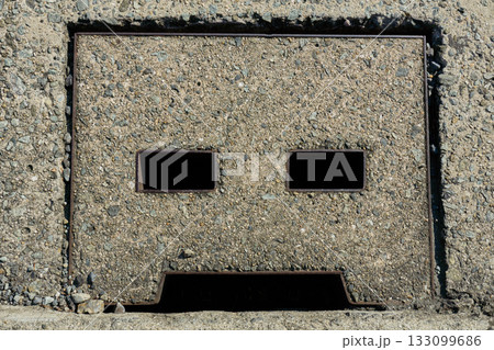 無機質なコンクリートの表情：側溝の蓋のクローズアップ 133099686