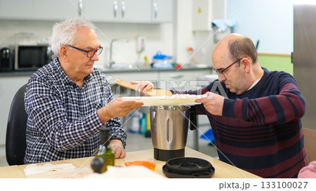 Two men with physical disability cooking in an inclusive kitchen Two men with physical disability cooking in an inclusive kitchen 133100027