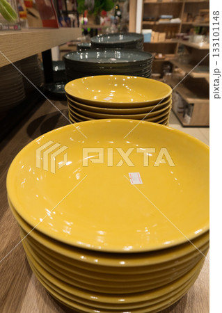 Stacked Yellow Plates on Wooden Shelf Stacked Yellow Plates on Wooden Shelf 133101148