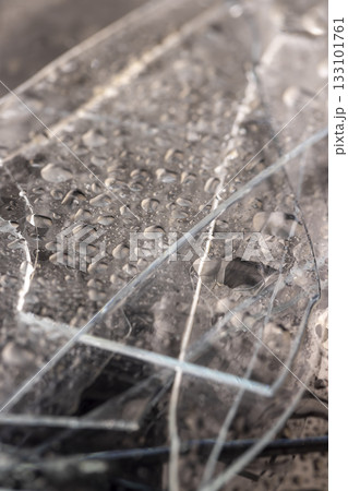 broken wet old glass lies on a black slate board with an uneven texture, pieces of broken transparent glass covered with water close up broken wet old glass lies on a black slate board with an uneven texture, pieces of broken transparent glass covered with water close up 133101761