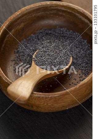 wooden bowl used in the manufacture of confectionery, a large amount of poppy seeds in a wooden bowl with a spoon 133101795