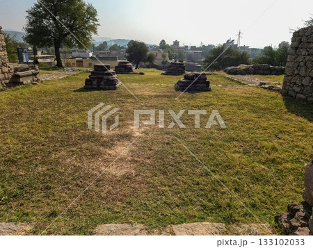 Entrance scene showing small weathered stone columns Jandial temple Taxila Pakistan 133102033