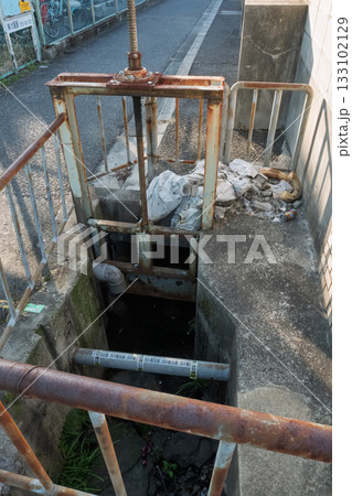 ガス管が露出した状態で水門前の水路を横断 133102129