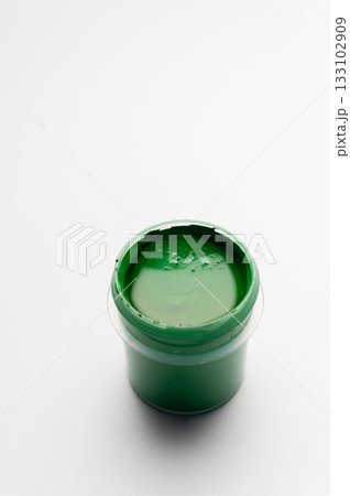 A jar of green colored gouache on a white background. Copy space. A transparent jar of colored water-soluble paint. A jar of green colored gouache on a white background. Copy space. A transparent jar of colored water-soluble paint. 133102909