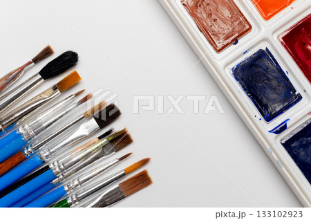 A set of watercolor paints and brushes on a white background with copy space. Design background art and painting A set of watercolor paints and brushes on a white background with copy space. Design background art and painting 133102923