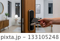 Smart keycard access system on wooden door in contemporary home interior with hand holding electronic entry card 133105248