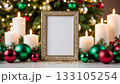 Ornate Golden Frame Displaying Joyeux Noel Message Surrounded by Festive Candles and Colorful Christmas Ornaments 133105254