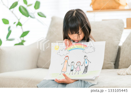 リビングのソファーでお絵描きした絵を見せる女の子 リビングのソファーでお絵描きした絵を見せる女の子 133105445