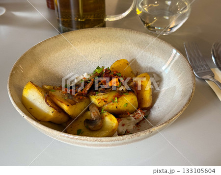 Roasted potatoes with mushrooms and herbs. Warm food, comfort, and homemade authenticity combining rustic flavors and simplicity. Roasted potatoes with mushrooms and herbs. Warm food, comfort, and homemade authenticity combining rustic flavors and simplicity. 133105604