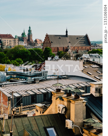 Wawel Royal Castle and Corpus Christi Basilica towering over Krakow rooftops on sunny spring day, offering stunning view from above, showcasing Poland rich history and architecture. Krakow skyline 133106984