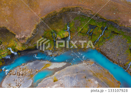 Aerial view of Sigoldugljufur Canyon in Iceland, featuring a turquoise river, moss covered cliffs, and cascading waterfalls amid rugged terrain. Aerial view of Sigoldugljufur Canyon in Iceland, featuring a turquoise river, moss covered cliffs, and cascading waterfalls amid rugged terrain. 133107928