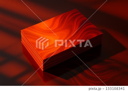 Stack of red business cards with abstract wavy pattern in dramatic lighting and shadows. Modern mockup for branding, print, or identity design. 133108341