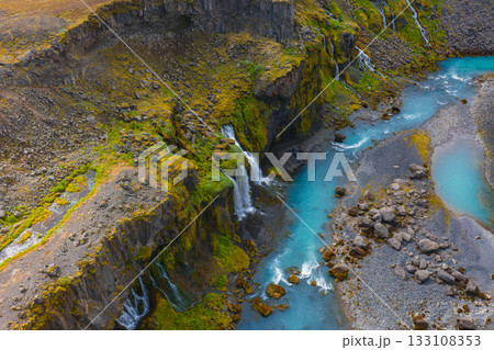 Aerial view of Sigoldugljufur Canyon in Iceland, featuring turquoise waters, moss covered cliffs, and cascading waterfalls in a rugged landscape. Aerial view of Sigoldugljufur Canyon in Iceland, featuring turquoise waters, moss covered cliffs, and cascading waterfalls in a rugged landscape. 133108353