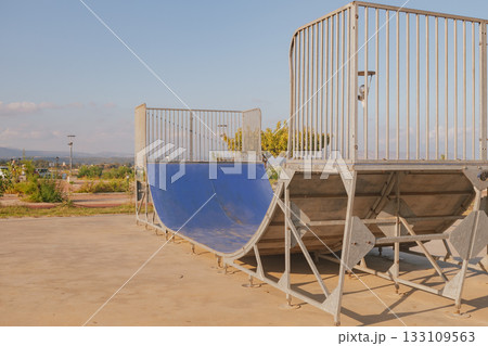 Empty concrete skate park ramp for skateboarding and rollerblading action sports Empty concrete skate park ramp for skateboarding and rollerblading action sports 133109563