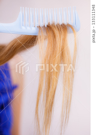Blonde woman with her damaged dry hair. 133111348