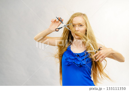 Girl with scissors for haircutting 133111350