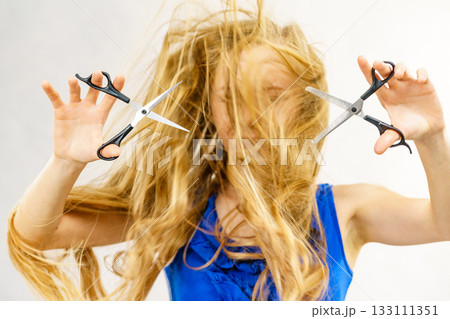 Young woman with scissors for haircutting Young woman with scissors for haircutting 133111351