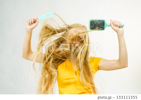 Girl blowing hair with comb brush Girl blowing hair with comb brush 133111355