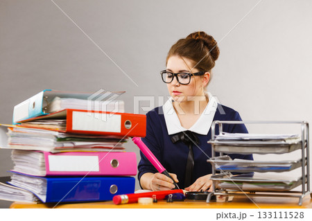 Business woman in office writing something down Business woman in office writing something down 133111528