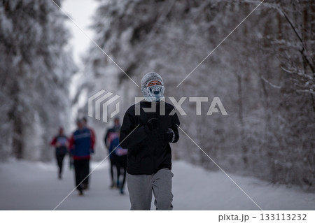 Man in wool balaclava in frost running winter marathon 133113232