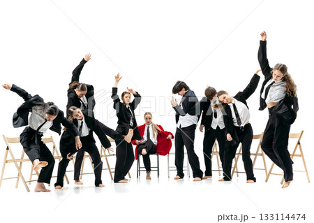 Business group dancing energetically around seated red-jacket leader expressing strong emotional contrast 133114474